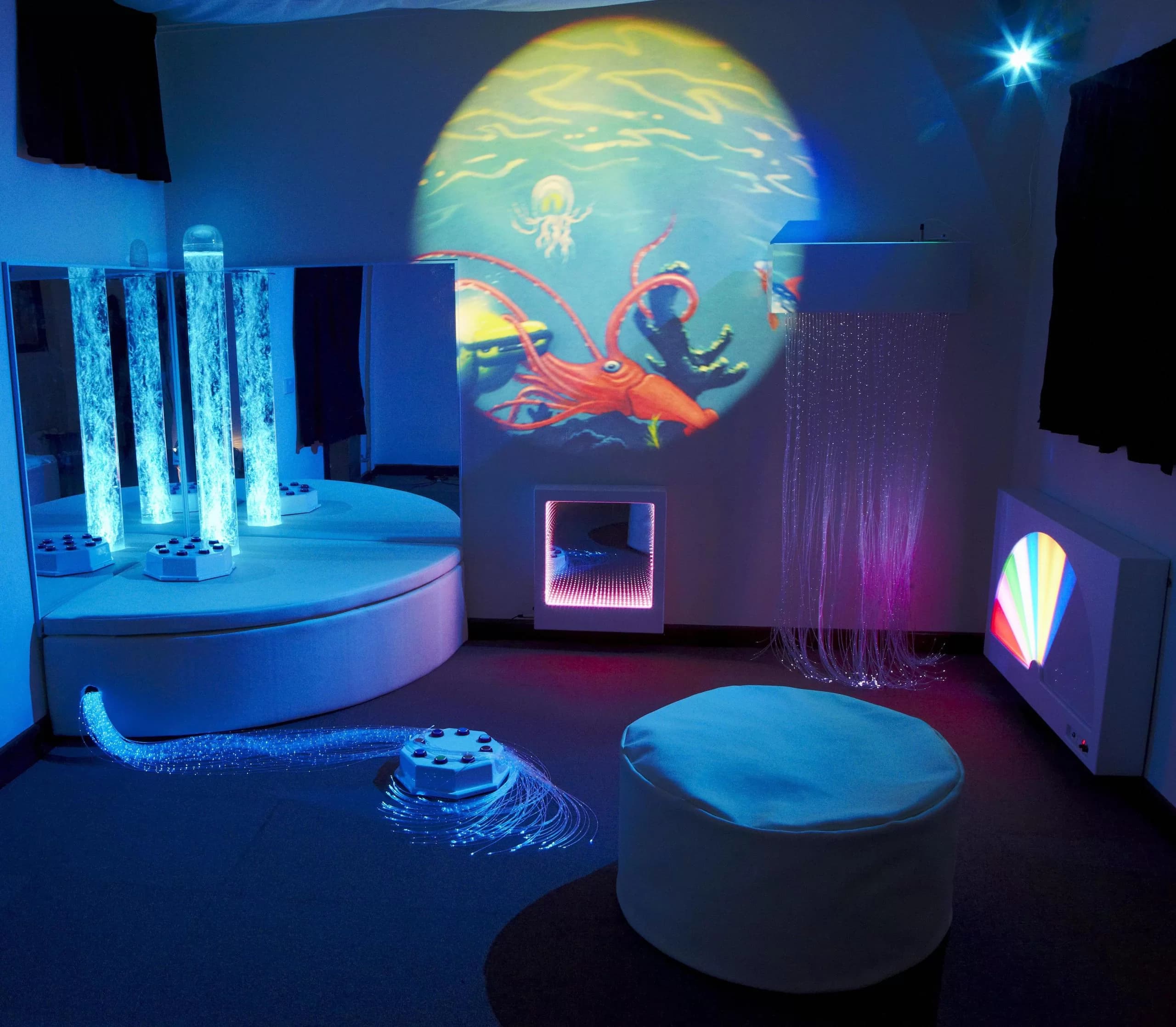 Salle Snoezelen avec enfants explorant un espace multi-sensoriel illuminé