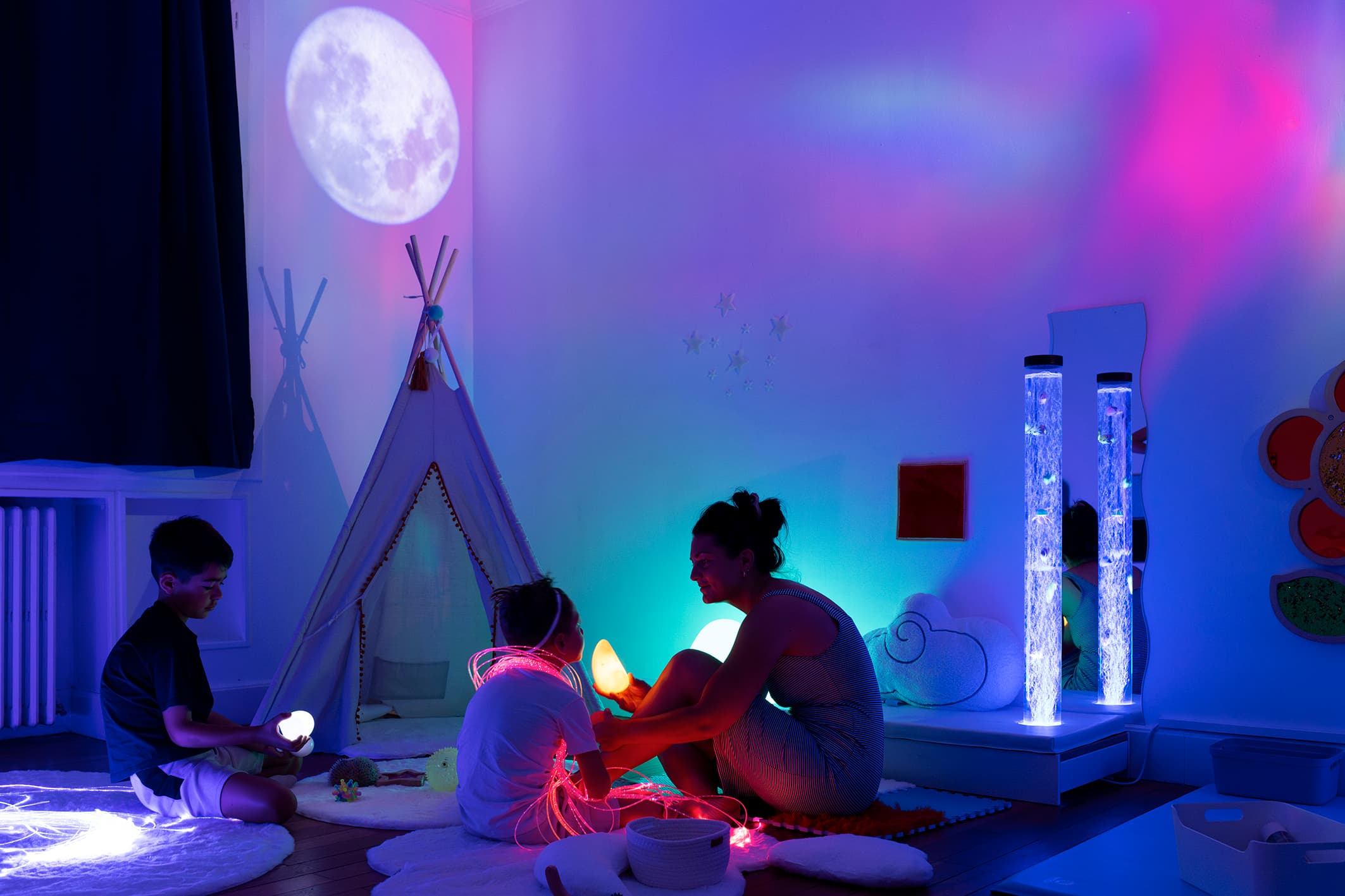 Salle Snoezelen avec enfants explorant un espace multi-sensoriel illuminé